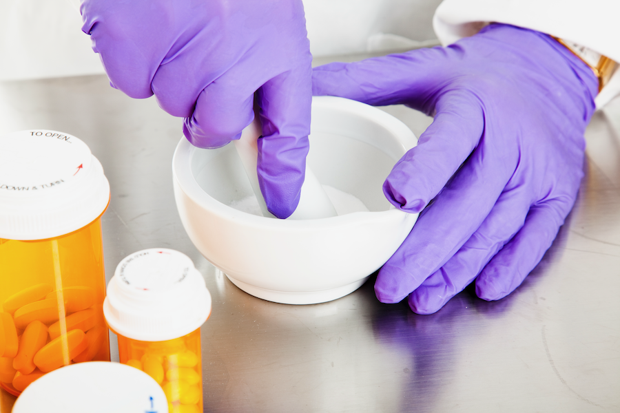 Pharmacist crushing medications with a mortar and pestle