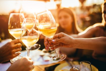 People clinking glasses with wine on the summer terrace of cafe or restaurant_Dietitians On Demand