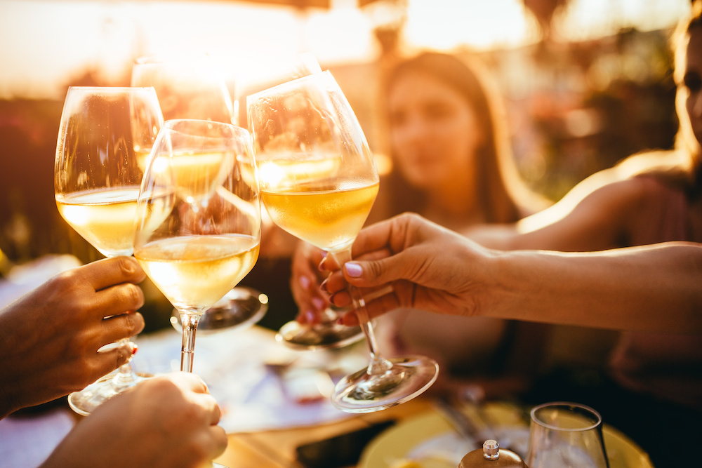People clinking glasses with wine on the summer terrace of cafe or restaurant_Dietitians On Demand