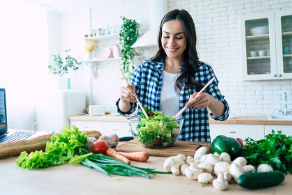 A woman creating a salad in her kitchen